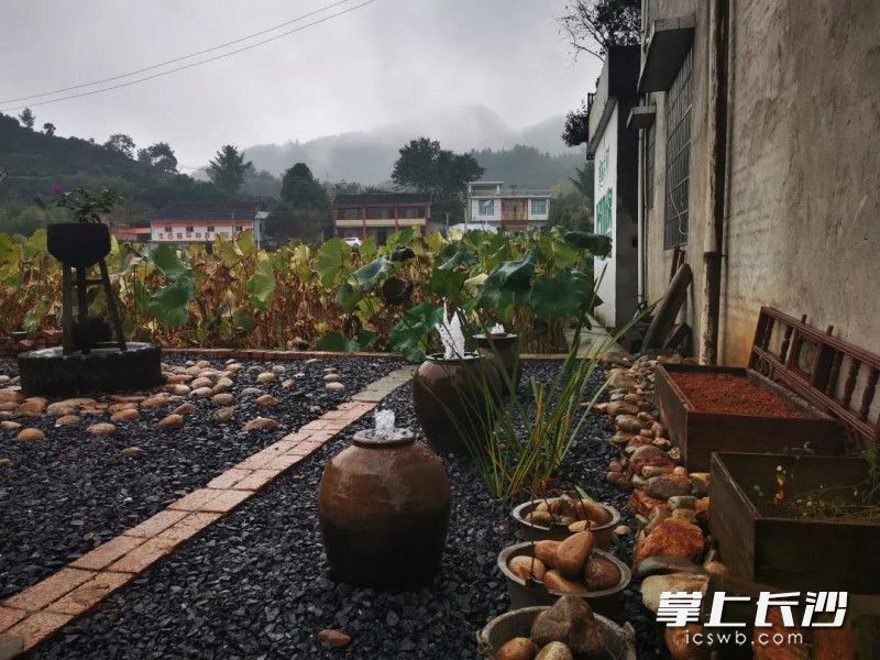 一些废旧的陶瓦，拆卸丢弃的旧屋梁、木雕花，经过组合造景，变成了村民庭院中一处别致的风景。