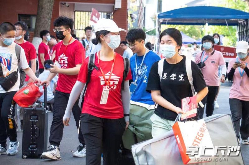 身穿红色衣服的“迎新志愿者”协助新生入校报到。湖南大学供图 身穿红色衣服的“迎新志愿者”协助新生入校报到。湖南大学供图