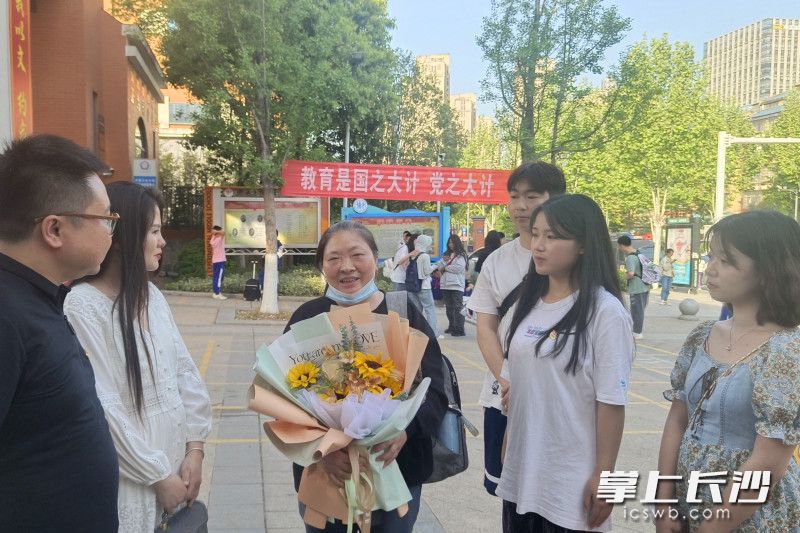 走出考点,志愿者和大学生为黄新生送上鲜花和祝福。 走出考点,志愿者和大学生为黄新生送上鲜花和祝福。