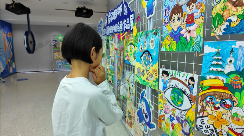 阿迪拉·阿力木驻足观看儿童绘画作品。