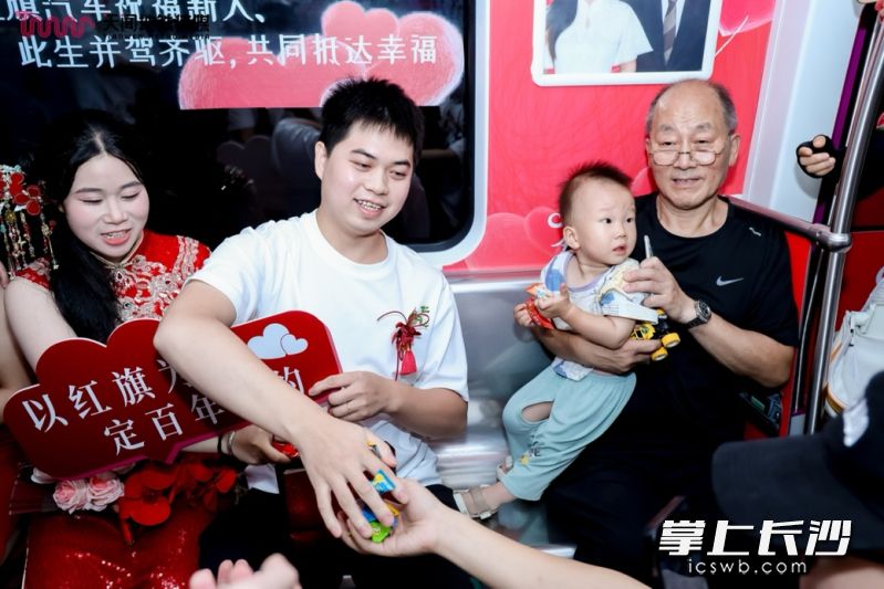 新人热情地为乘客派发红包、喜糖。 新人热情地为乘客派发红包、喜糖。