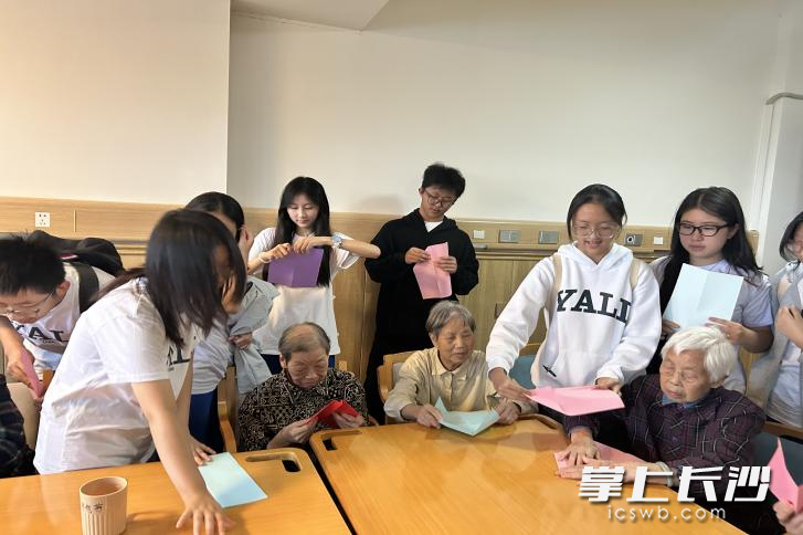 同学们还与老人一起折纸飞机,重拾简单的快乐。 同学们还与老人一起折纸飞机,重拾简单的快乐。