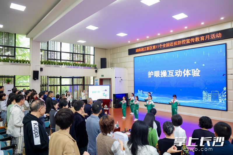 几名学生带领与会人员进行护眼操互动体验。