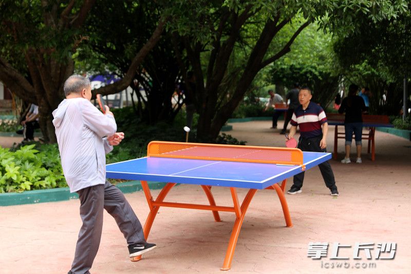 市民在烈士公园健身广场打乒乓球。