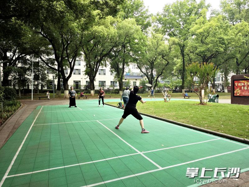 市民在烈士公园健身广场打羽毛球。