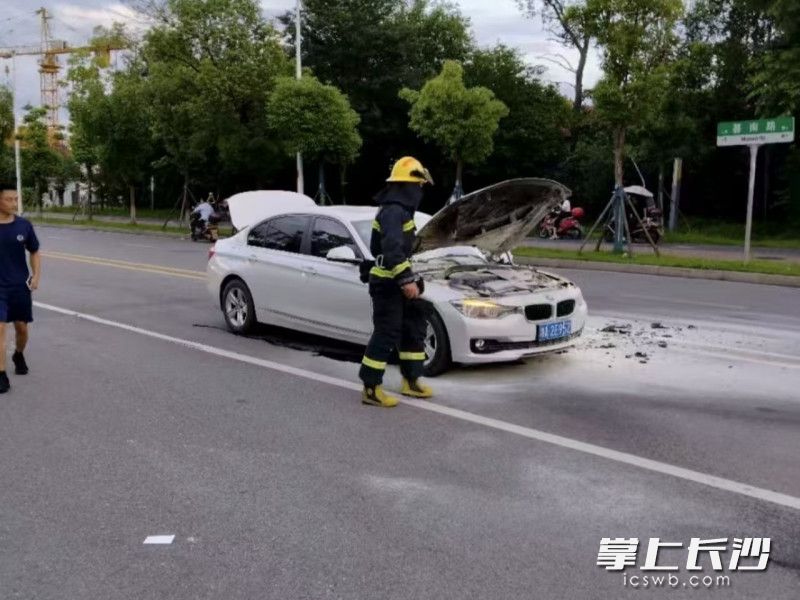 消防员在扑救自燃的汽车。 消防员在扑救自燃的汽车。