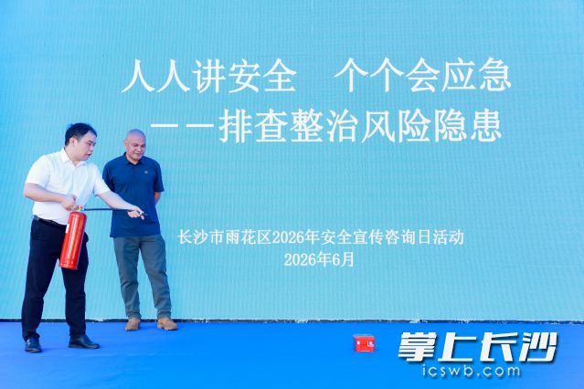 市民上台体验灭火器、防烟面罩实操。