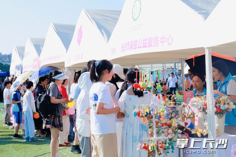 市民在“公益市集”摊位前驻足了解。