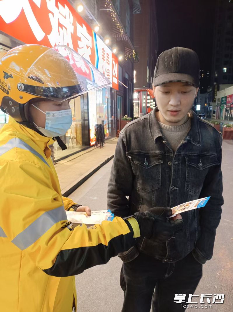 万素娟在送单途中向行人发放消防宣传单。 受访者供图 万素娟在送单途中向行人发放消防宣传单。 受访者供图