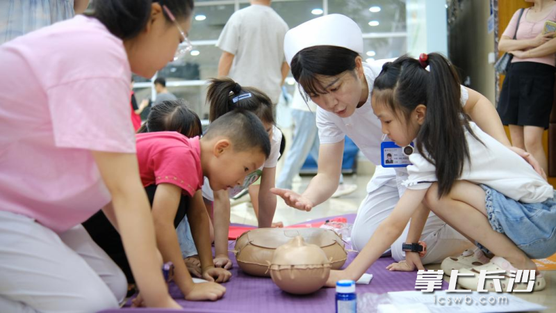 护士老师手把手向小学员讲解心肺复苏的实操要领。 护士老师手把手向小学员讲解心肺复苏的实操要领。