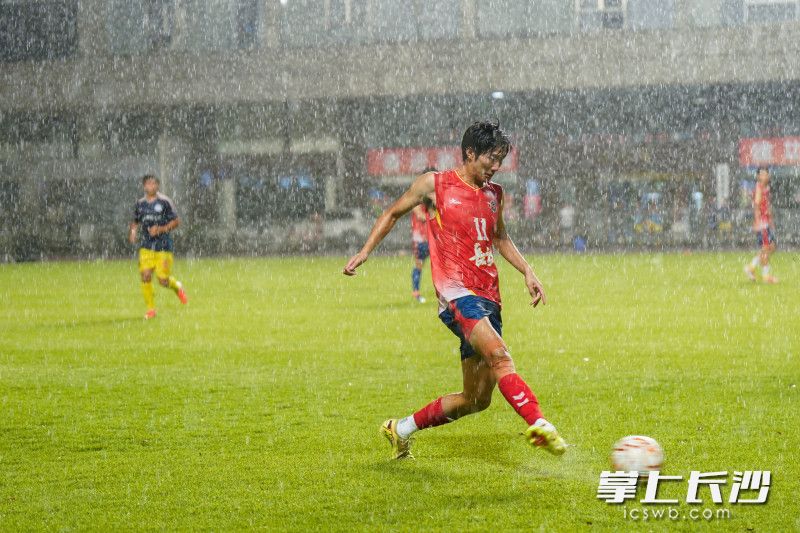 长沙队队员雨中解围。 长沙队队员雨中解围。