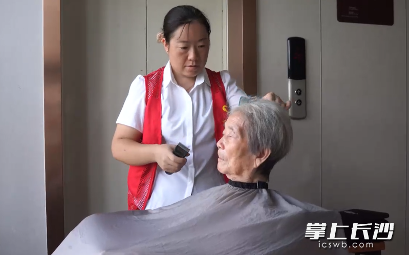正在为周奶奶理发的向冰。市民政局 供图