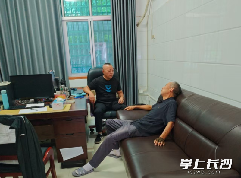 宁乡市救助站工作人员与老人谈心。