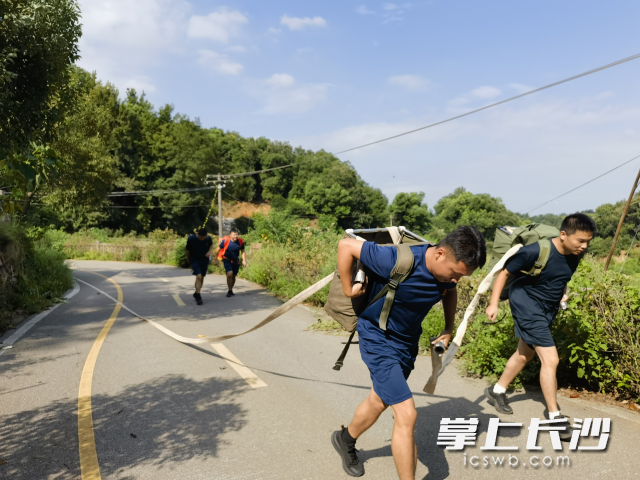 队员们从低处水源地，沿着蜿蜒陡坡铺设水带。