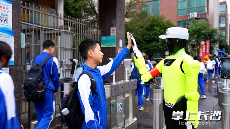 开学首日,机器人和入校学生击掌。 均为长沙晚报通讯员姚龙摄 开学首日,机器人和入校学生击掌。 均为长沙晚报通讯员姚龙摄