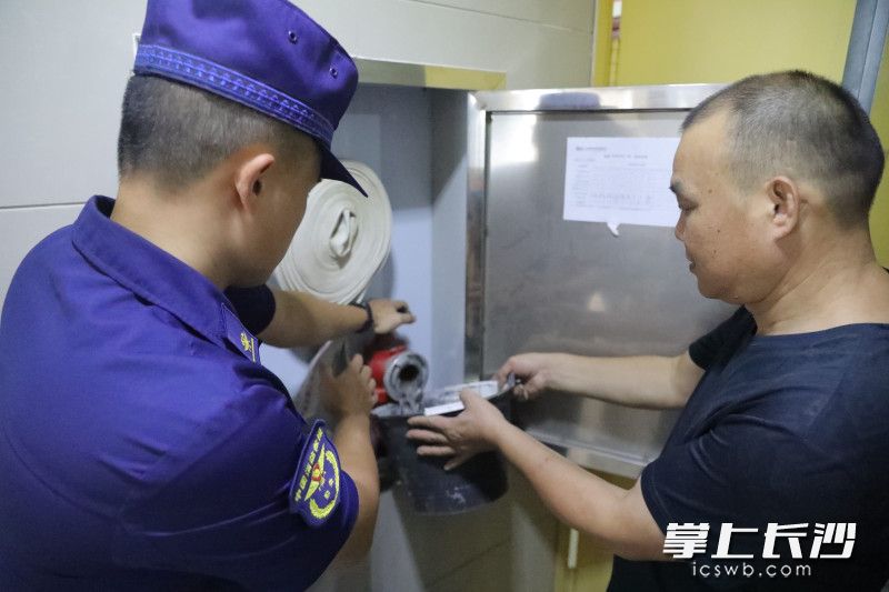 消防员和物业工作人员现场测试消防栓阀门是否正常出水。 消防员和物业工作人员现场测试消防栓阀门是否正常出水。