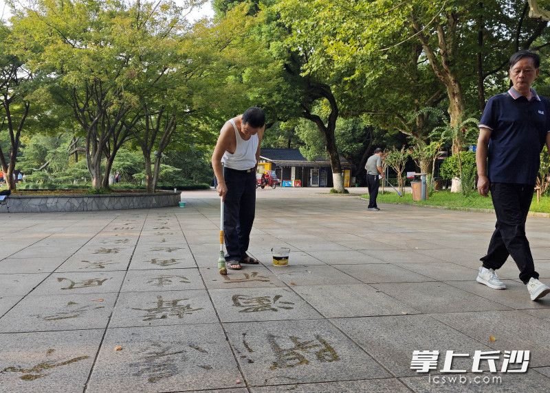 今日清晨,70岁的凌宇安正烈士公园年嘉湖畔广场写地书。均为长沙晚报全媒体记者 贺文兵 摄 今日清晨,70岁的凌宇安正烈士公园年嘉湖畔广场写地书。均为长沙晚报全媒体记者 贺文兵 摄