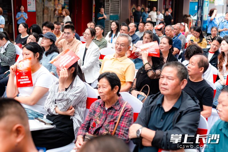 活动现场，不少市场经营户、社区居民坐于台下，认真聆听反假货币知识讲解。