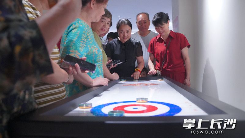 居民体验桌上冰壶乐趣。 居民体验桌上冰壶乐趣。