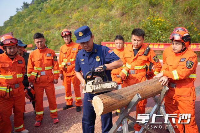 教官手握油锯示范，纠正参训人员操作细节。 均为长沙晚报全媒体记者林暘摄