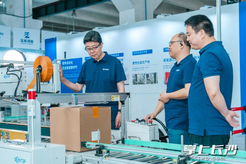 深拓智能工作人员向客商推介智能打包设备。深拓智能 供图 深拓智能工作人员向客商推介智能打包设备。深拓智能 供图
