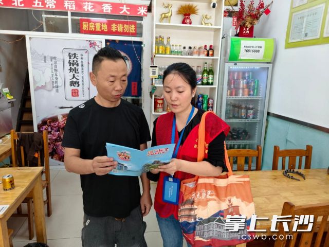 社区网格员向商户宣传燃气安全知识。  均为长沙晚报通讯员 付彬供图