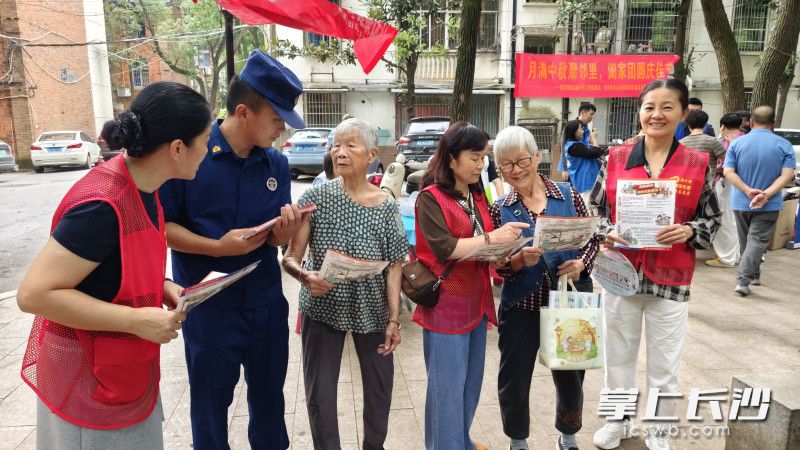 社区志愿者与消防宣传员向居民发放消防安全宣传手册。 通讯员 董文文 摄