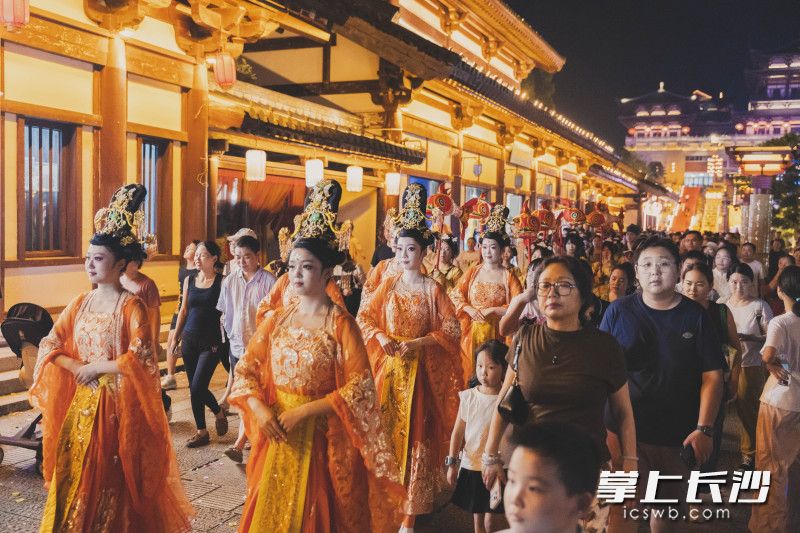 夜幕下的铜官窑，古装NPC衣饰华美，游客穿行其间，一步踏入盛唐灯火人间。
