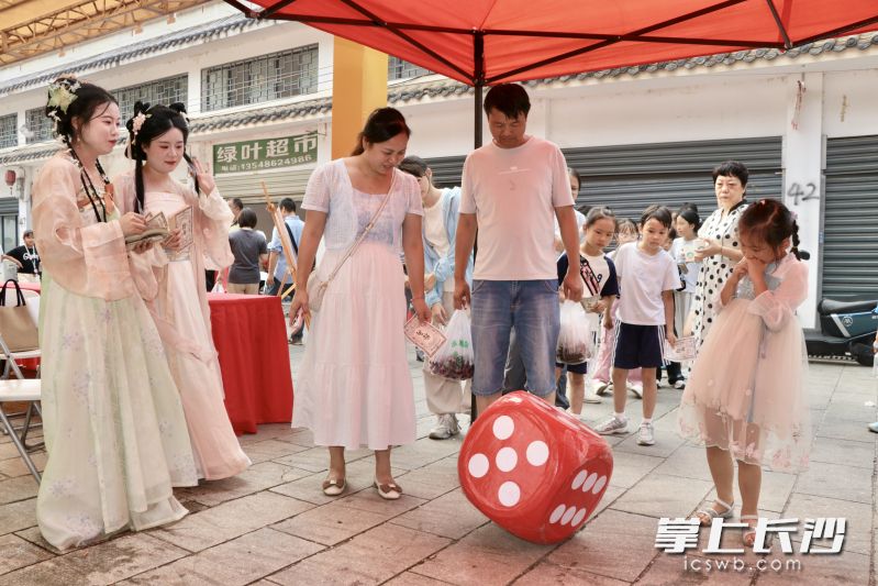 游客们在三仙街非遗集市上体验互动小游戏。