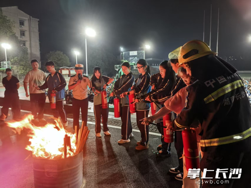 消防宣传员指导学生进行灭火实操。 通讯员 杨来富 摄