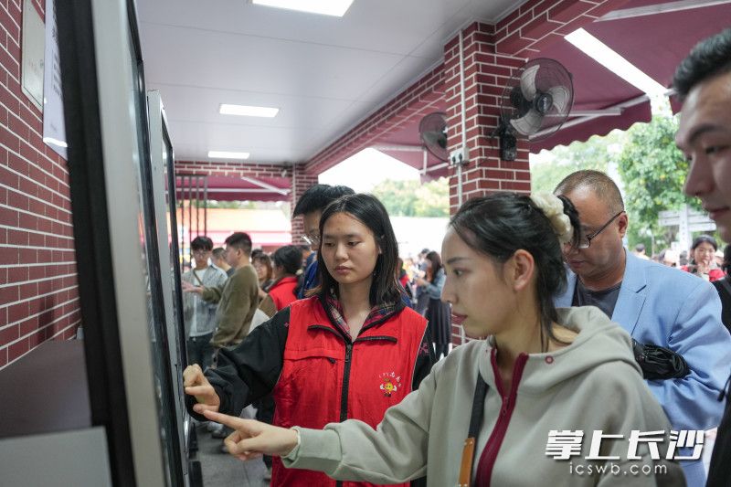 志愿者正在引导游客正确购买观光小火车票。