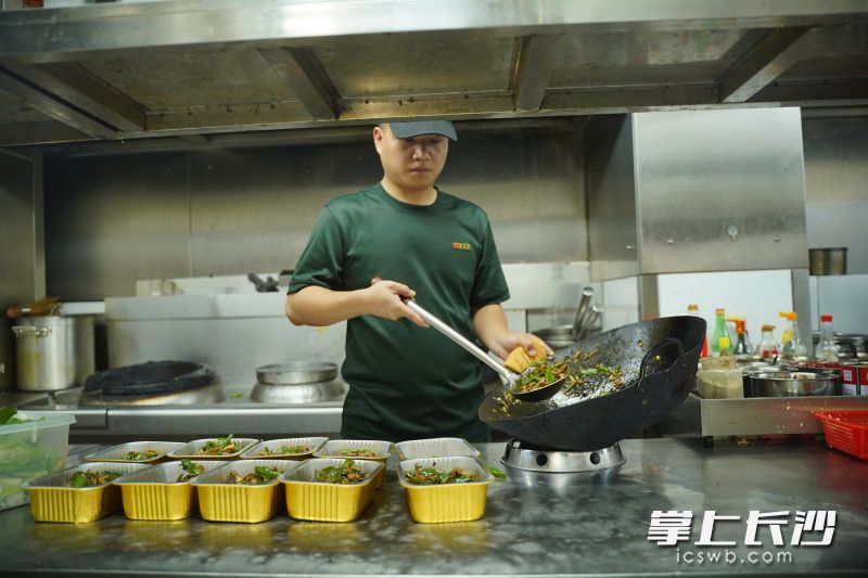 苏朋成正在后厨炒菜装盒。均为长沙晚报全媒体记者 李茂健 摄 苏朋成正在后厨炒菜装盒。均为长沙晚报全媒体记者 李茂健 摄